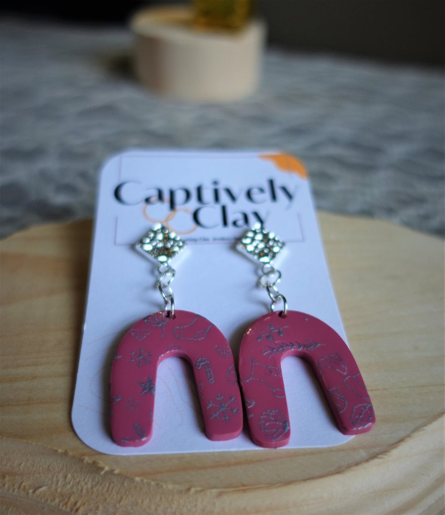 red arched earrings with silver components and silver stenciled pattern