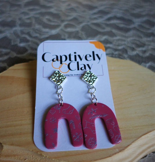 red arched earrings with silver components and silver stenciled pattern